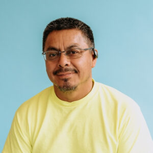 point west member in yellow shirt smiling at the camera
